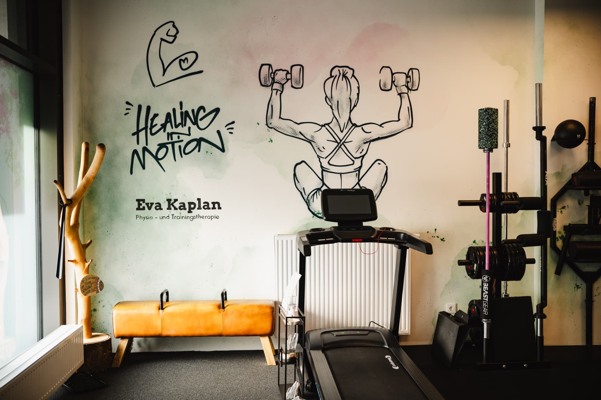Wand mit „Healing in Motion"-Schriftzug und Eva-Kaplan-Logo