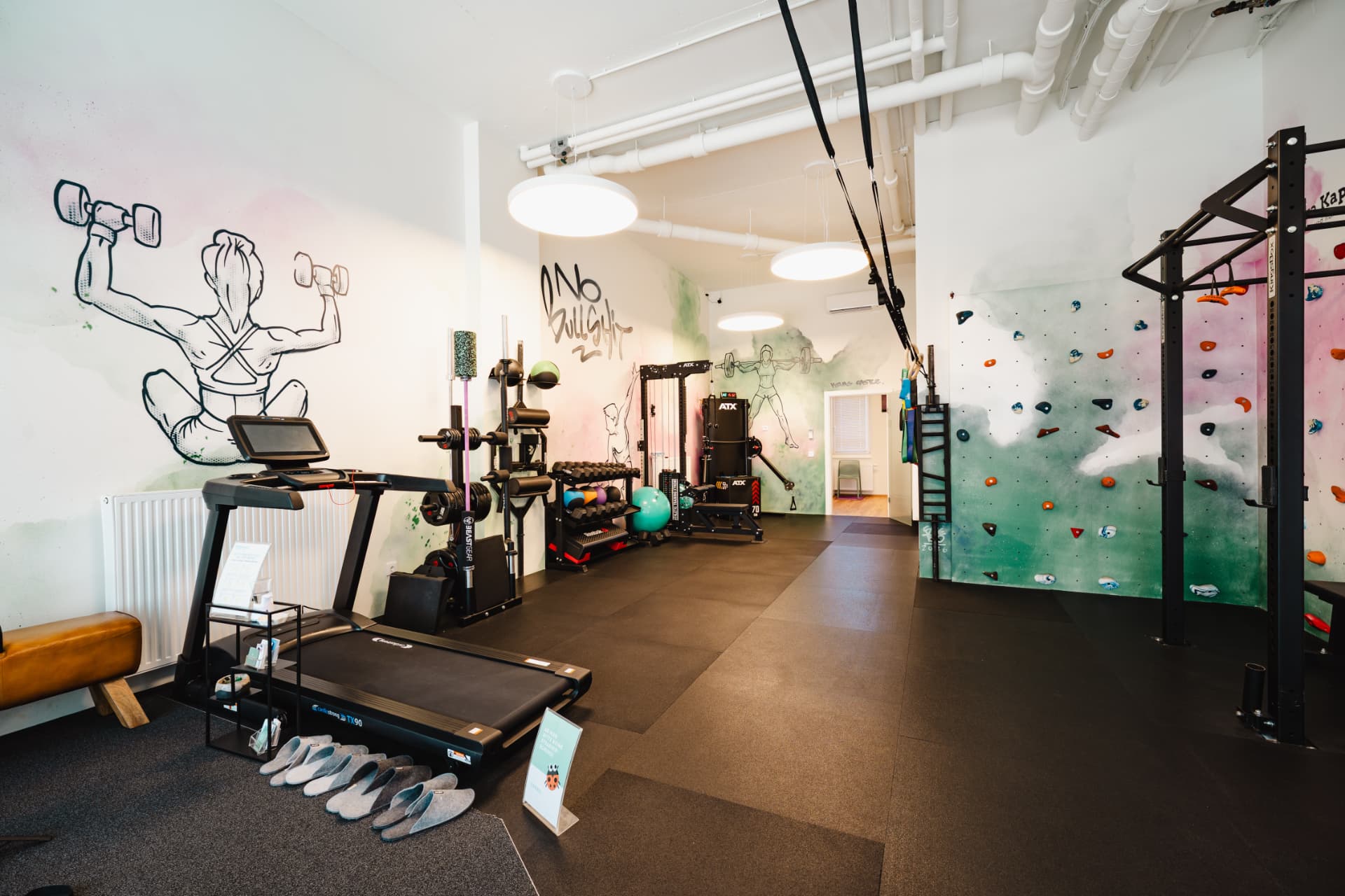 Blick durch den Trainingsraum mit Laufband, Rig und Kletterwand